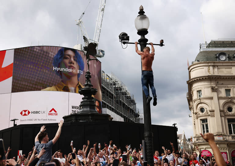 Фанат повис на фонарном столбе на площади Пикадилли в центре Лондона в преддверии финального матча Евро-2020