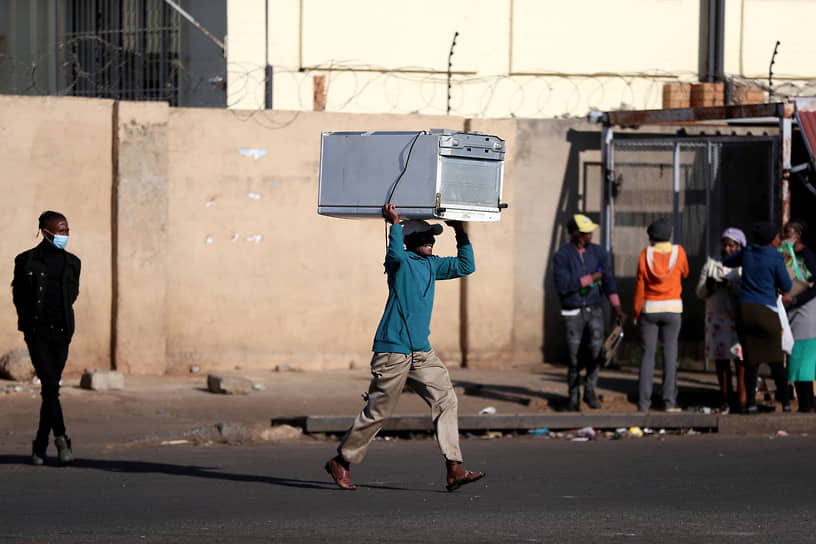 Катлехонг, ЮАР. Мужчина во время разграбления торгового центра в ходе беспорядков в знак протеста против заключения экс-президента страны Джейкоба Зумы  