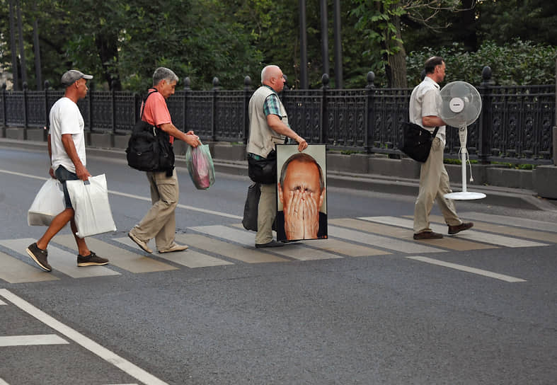 Москва, Россия. Мужчины идут через дорогу по пешеходному переходу в центре города 