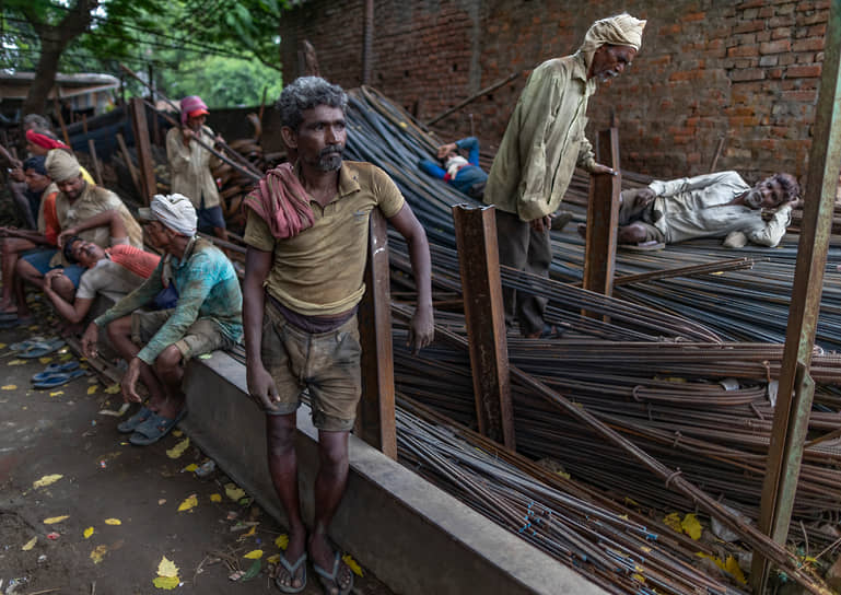 Праяградж, Индия. Рабочие при перевозке железных прутьев, используемых при строительстве зданий