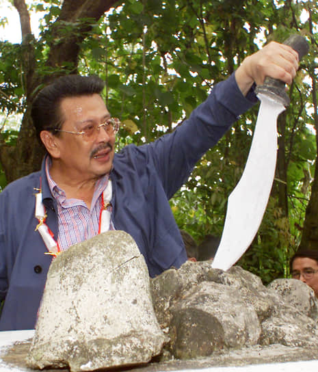 Президент Филиппин Джозеф Эстрада сжимает меч, запечатанный в куске скалы на историческом месте в городе Сан-Мигель. На этом месте находилась штаб-квартира филиппинских революционеров, которые сражались против испанцев в конце XIX века, 2001 год
