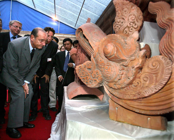 Президент Франции Жак Ширак осматривает голову Феникса во время посещения археологических раскопок в Ханое, 2004 год
