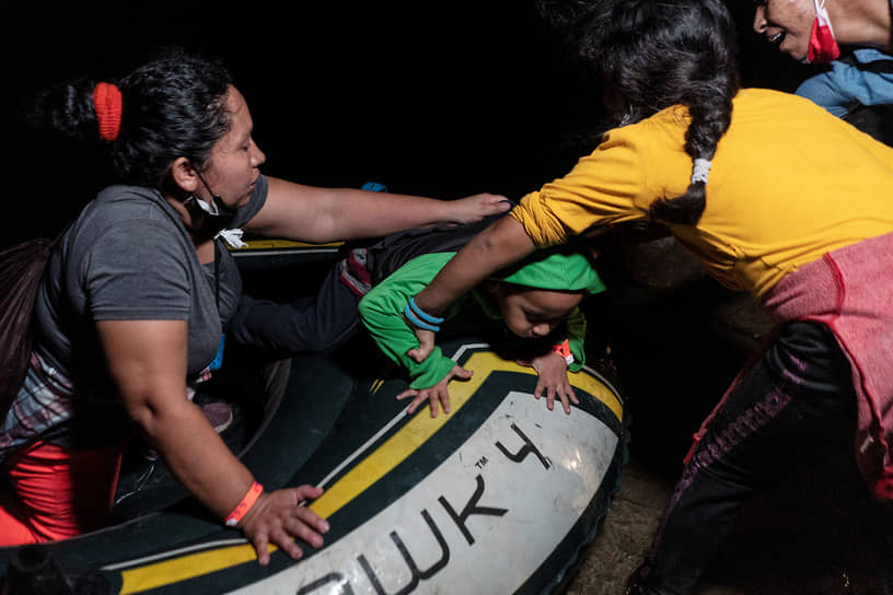 Рома, США. Мигранты из Мексики пересекают реку Рио-Гранде на надувной лодке 
