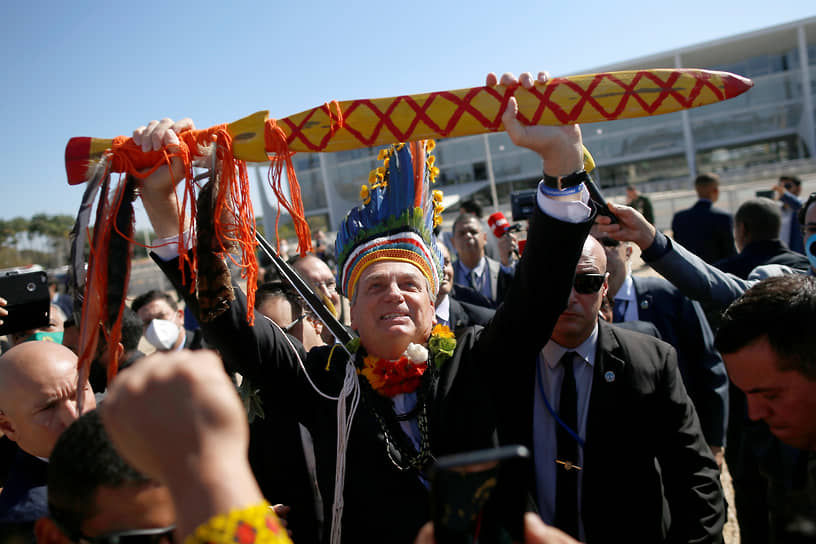 Бразилиа, Бразилия. Президент Бразилии Жаир Болсонару поднимает деревянный меч во время встречи со своими сторонниками из числа коренных народов