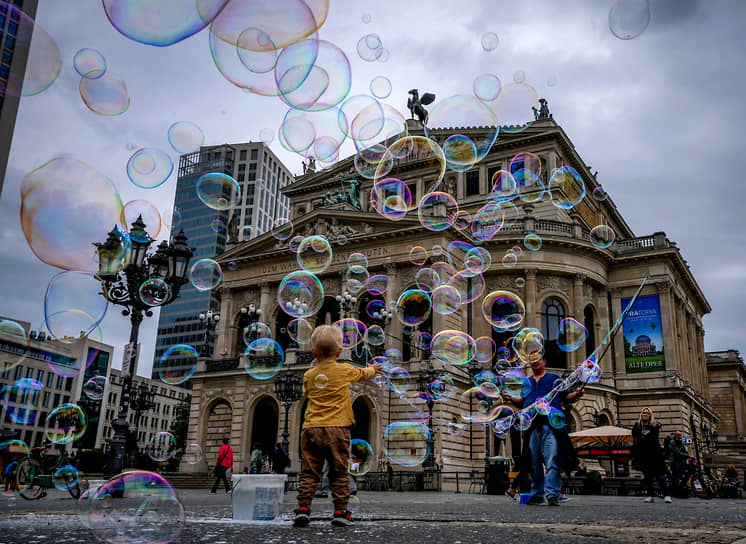 Франкфурт, Германия. Мальчик играет с мыльными пузырями на площади у оперы