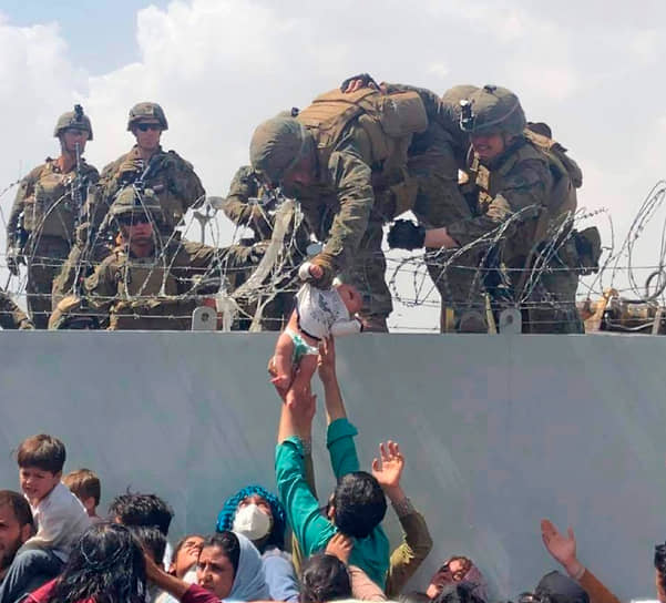22 августа президент США Джо Байден рассказал, что с середины августа из Афганистана вывезено 28 тыс. человек, с июля — 33 тыс.
&lt;br>На фото: афганец передает американским солдатам ребенка 

