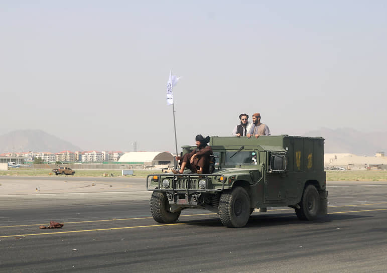 Талибы патрулируют взлетно-посадочную полосу в Кабуле на трофейном автомобиле через день после вывода американских войск