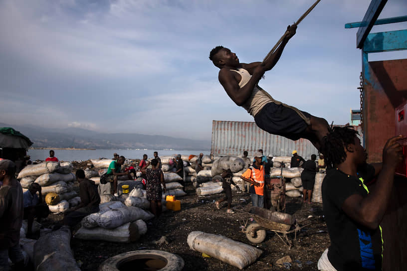 Порт-о-Пренс, Гаити. Мужчина забирается на грузовик во время погрузки угля