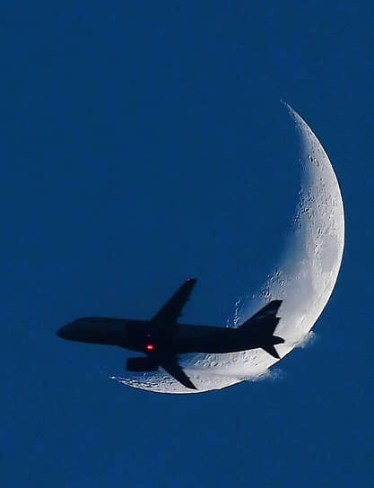 Самолет на фоне луны