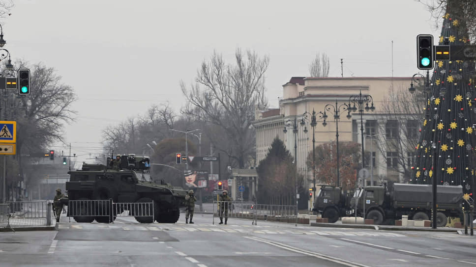 Казахстанские военнослужащие стоят на контрольно-пропускном пункте в Алматы