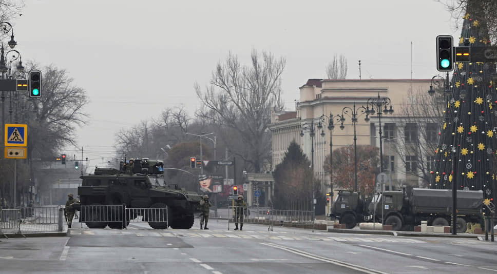 Казахстанские военнослужащие стоят на контрольно-пропускном пункте в Алматы