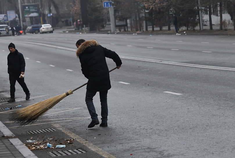 Мужчина убирает мусор с проезжей части