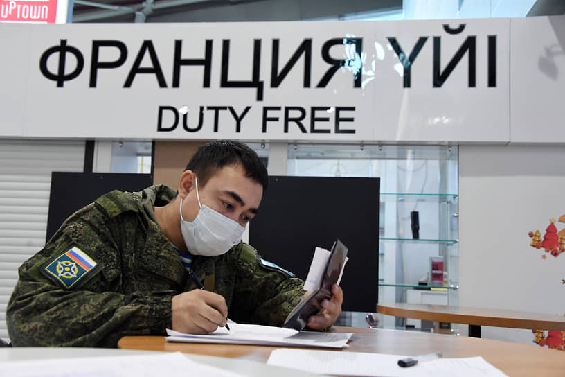 Российский военнослужащий заполняет документы в здании аэропорта