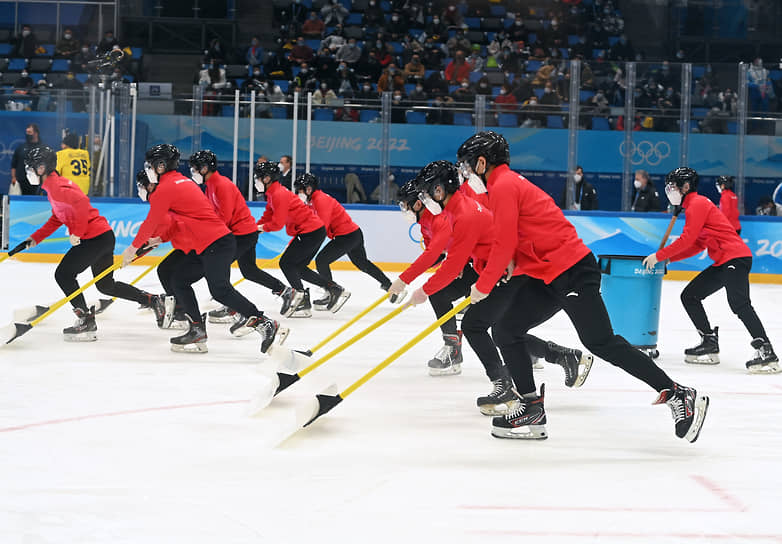 Сотрудники Дворца спорта в Пекине готовят лед к матчу