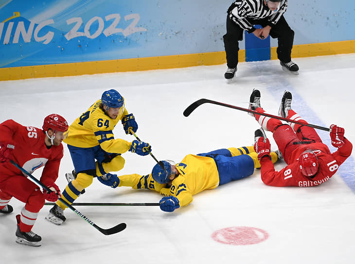 Игроки сборных России и Швеции борются за шайбу 