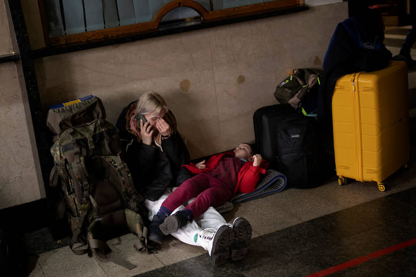 Женщина с ребенком ожидает поезда, чтобы покинуть Киев