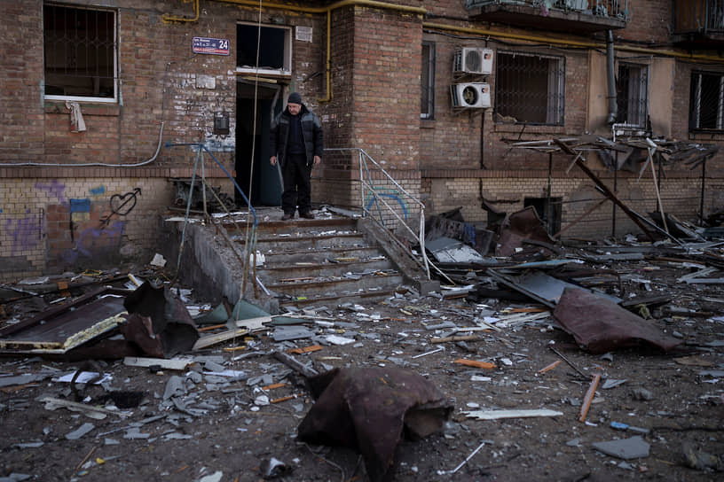 Местный житель стоит у подъезда дома после обстрела в Киеве