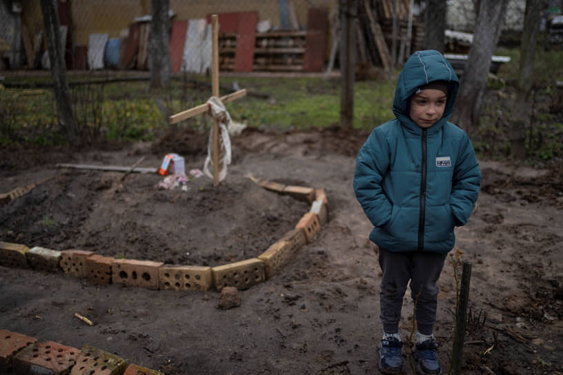 Украинский мальчик стоит во дворе на окраине Киева