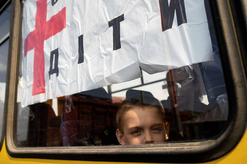 Мальчик смотрит в окно автобуса во время эвакуации около Лимана