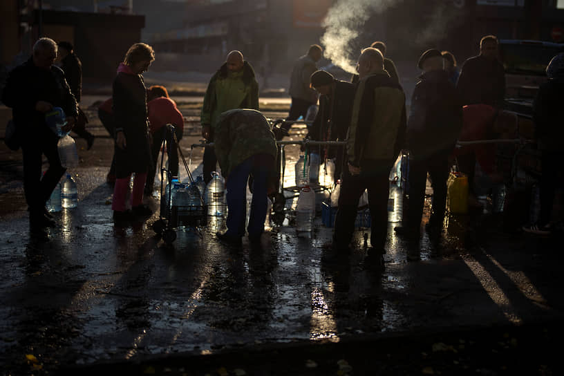 Местные жители наполняют бутылки питьевой водой из бака в центре Николаева