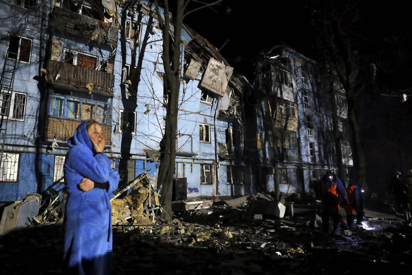 Женщина около поврежденного дома в Запорожье