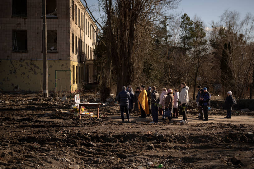Священник совершает богослужение на месте снесенного после авиаудара здания в Бородянке