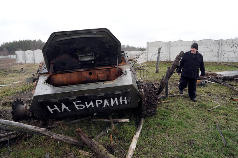 Местный житель проходит мимо подбитого бронетранспортера в селе Русские Тишки под Харьковом