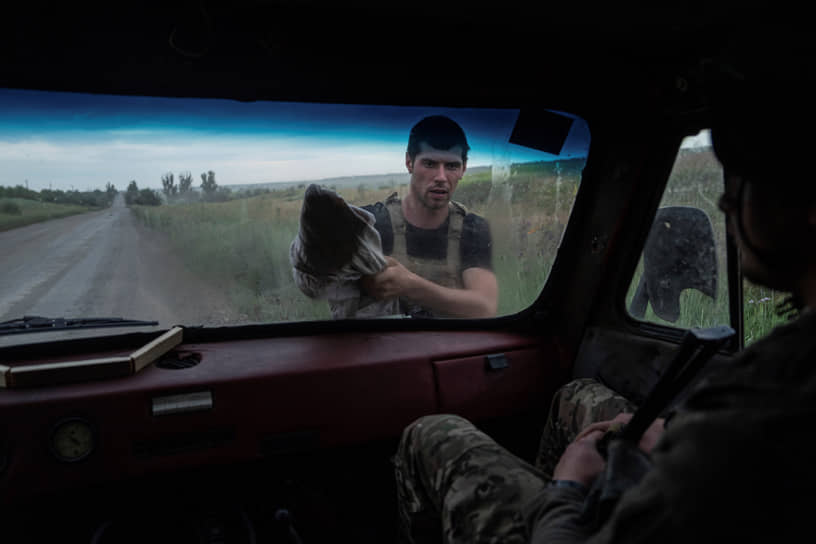 Украинский военнослужащий 28-й бригады моет окно автомобиля 