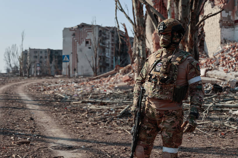 Боец ЧВК «Вагнер» охраняет территорию возле пострадавших в результате обстрела жилых домов в Бахмуте (Артемовске)