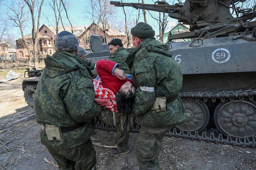 Военнослужащие эвакуируют местную жительницу из больницы Мариуполе 