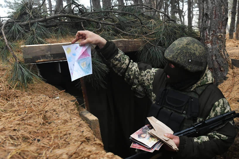 Российский военнослужащий рассматривает письма и рисунки детей, переданные журналистами
