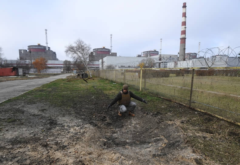 Сотрудник «Росэнергоатома» у воронки от разорвавшегося снаряда на территории Запорожской атомной электростанции 