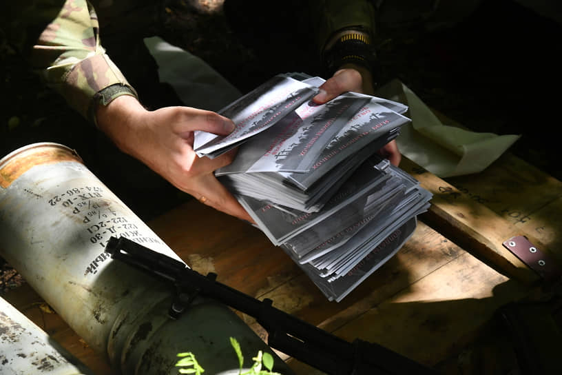 Российский военный держит листовки для агитационного снаряда на Сватовском направлении