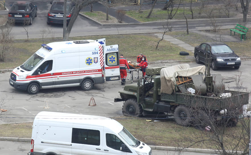 Сотрудники киевской скорой помощи увозят человека в военной форме 
