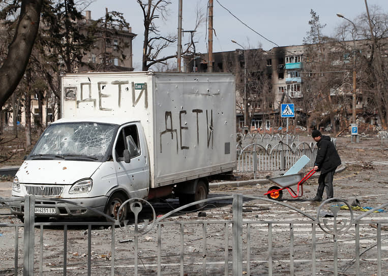 Местный житель у грузовика с надписью «дети» в Мариуполе