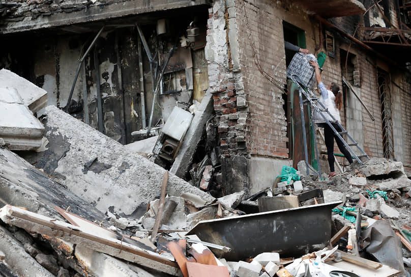 Местные жители забирают свои вещи из разрушенного дома в  Мариуполе