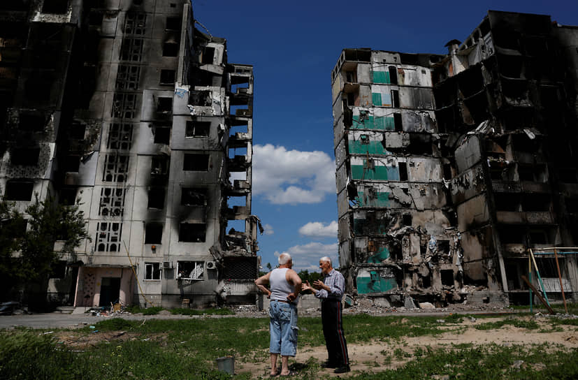 Жители поселка Бородянка Киевской области на фоне разрушенных зданий