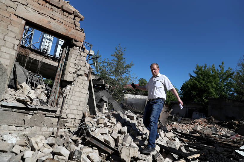 Мужчина идет среди обломков дома в Харькове 