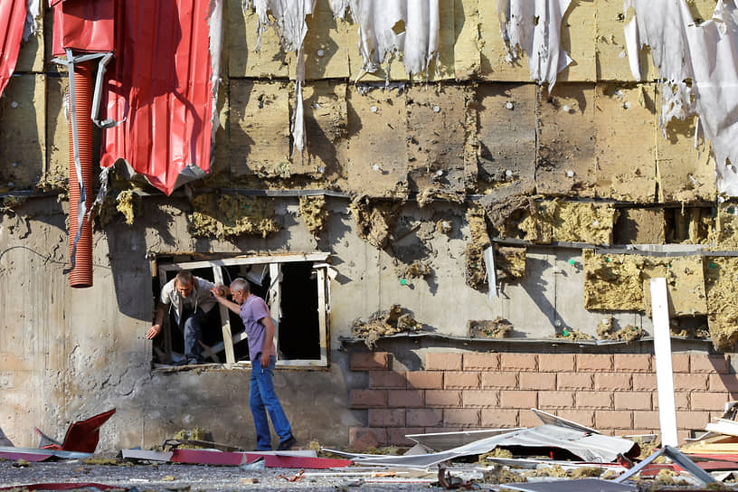 Житель Донецка покидает пострадавшее от обстрела здание 