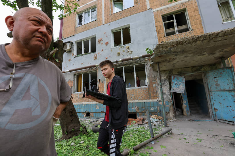 Местные жители у пострадавшего от обстрела жилого дома в Донецке