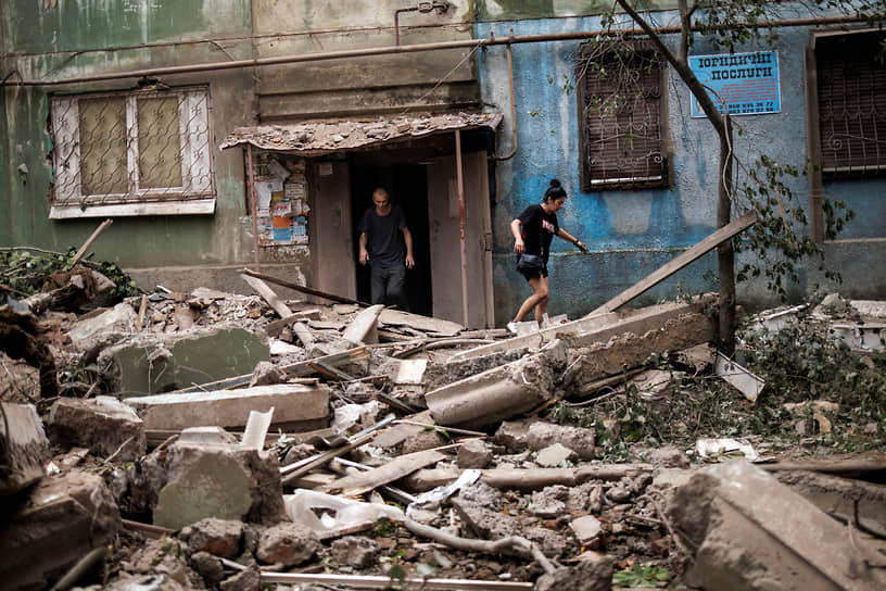 Местные жители возле уничтоженного после ракетного удара здания в Константиновке