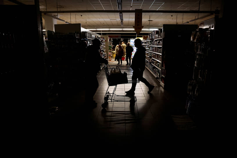 Посетители супермаркета во время отключения электричества в Харькове