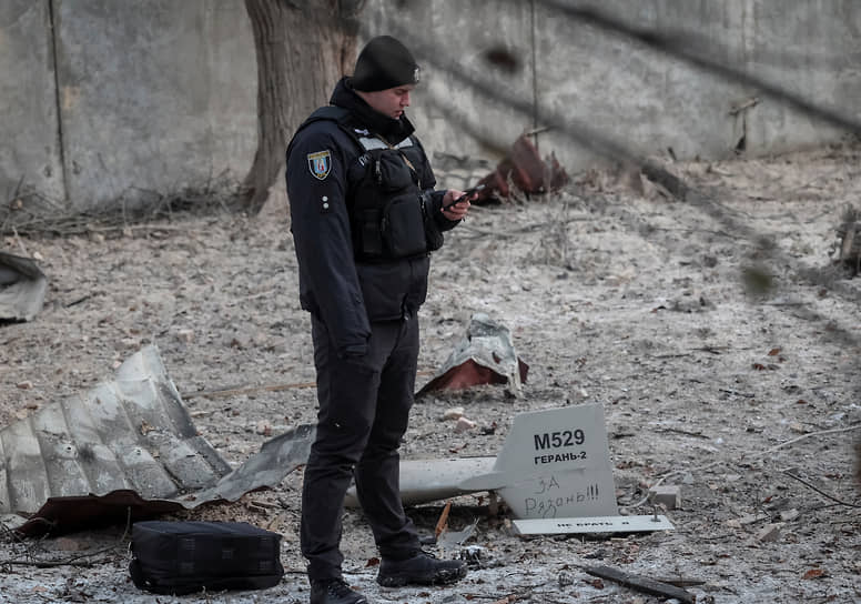 Сотрудник национальной полиции стоит возле упавшего беспилотника в Киеве