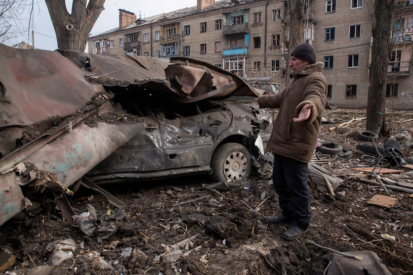 Житель села Константиновка на Донбассе рядом с обломками своего автомобиля, разрушенного в результате обстрелов
