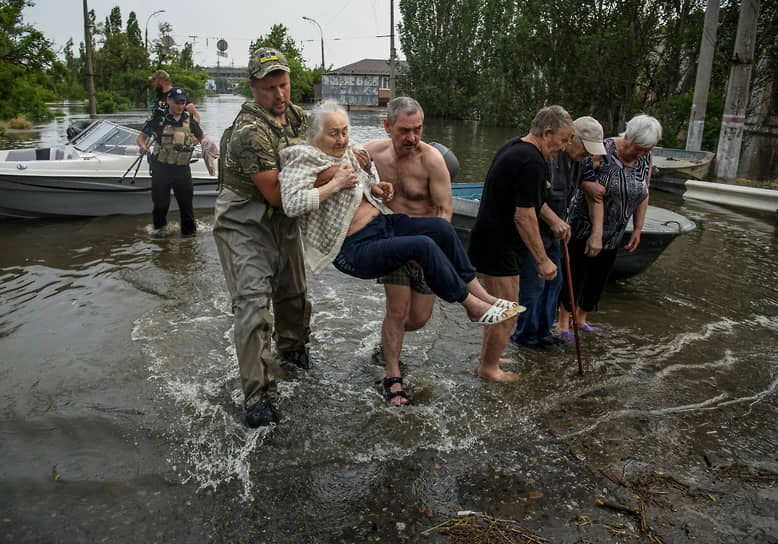 Спасатели эвакуируют местных жителей из зоны затопления после прорыва плотины Каховской ГЭС