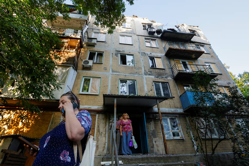 Местные жители у поврежденной пятиэтажки в Донецке