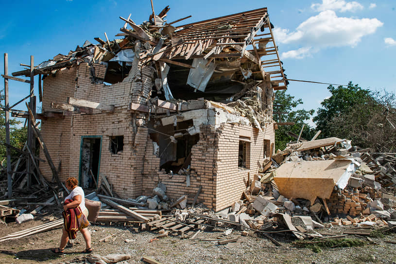 Жительница Киева выносит вещи из своего дома, разрушенного в результате ракетного удара