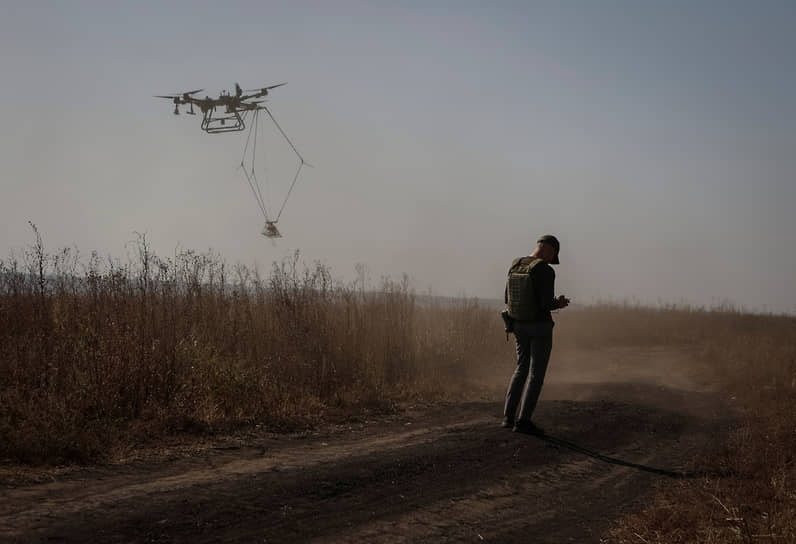 Волонтер управляет дроном при разминировании поля в Харьковской области