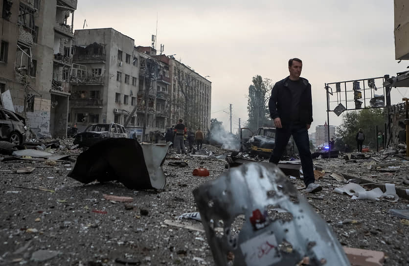 Жители Харькова рядом со зданиями, пострадавшими от ракетного обстрела