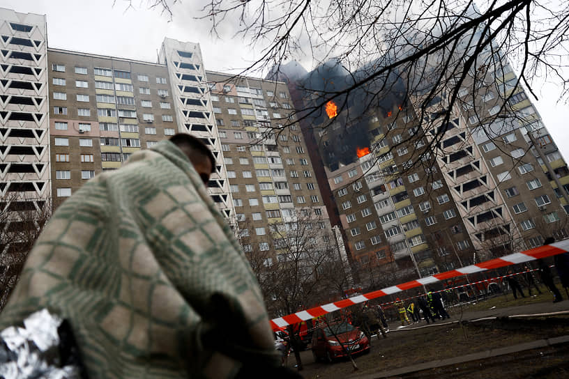 Человек около поврежденного здания в Киеве
